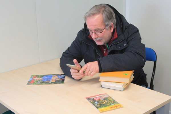 Markus Kobelt mit Handy und Bücher