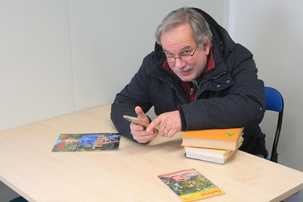 Markus Kobelt mit Handy und Bücher